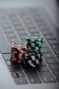 Stacks of poker chips on a laptop computer. Online casino concept 库存照片