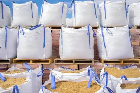 Stacks of raffia large sand sacks stacked over wooden pallets with bricks Stock Photos