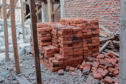 Stacks of red bricks are prepared to build the walls of the house Foto stock