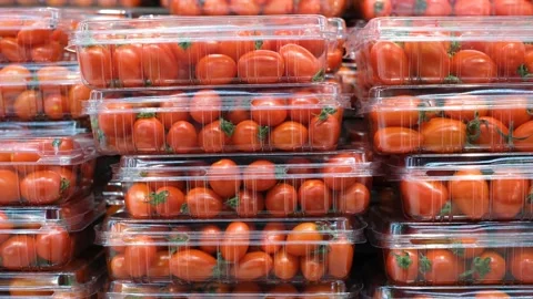 Stacks of red cherry tomatoes in plastic containers close-up in a supermarket. Stock Footage 220242875