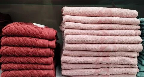 Stacks of Soft Red and Neutral Cotton Towels Neatly Folded Foto stock