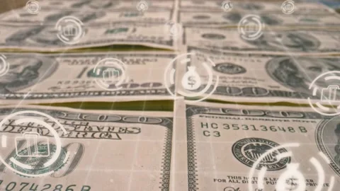Stacks of US dollar bills lying on surface while glowing financial icons Stock Footage 308641198