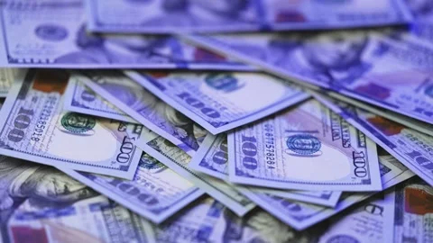 Stacks of U.S. dollar bills spread across a surface, showcasing various Stock Footage 327698890
