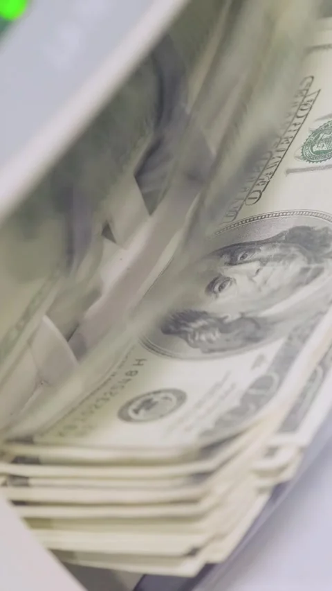 Stacks of US dollars being processed and counted in an automatic money counting Stock Footage 317737196