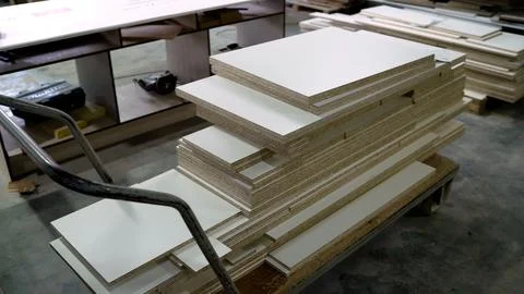 Stacks of white laminated particle board on industrial trolley in furniture Stock Photos