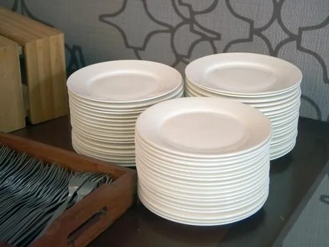 Stacks of white plates on a buffet table Stock Photos