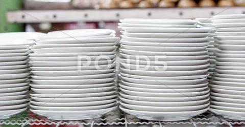 Stacks of white plates in warehouse Stock Photos
