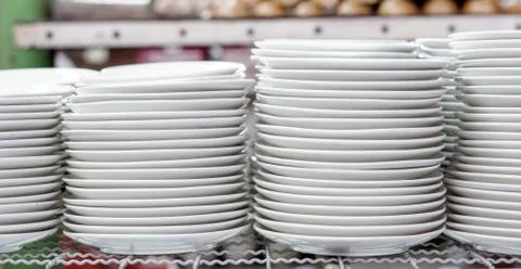 Stacks of white plates in warehouse Stock Photos