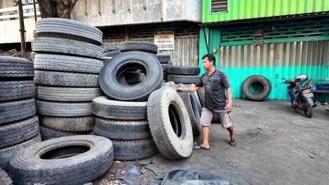 Stacks of worn tires fill the dusty yard Stock Footage 345199342