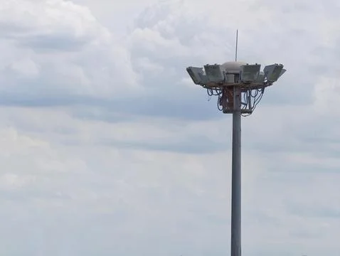 Stadium floodlight tower against cloudy sky with dramatic weather and minim.. Stockfoto's