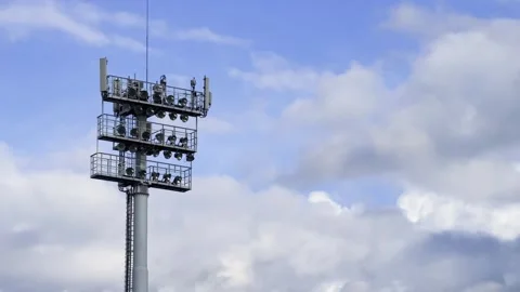 Stadium floodlight tower with mounted lamps and telecom antennas against a Stock Footage 341412306