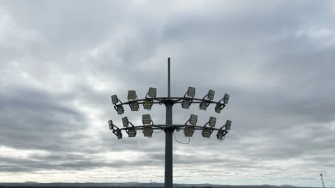 Stadium floodlights tower against a cloudy sky Video stock 340381794