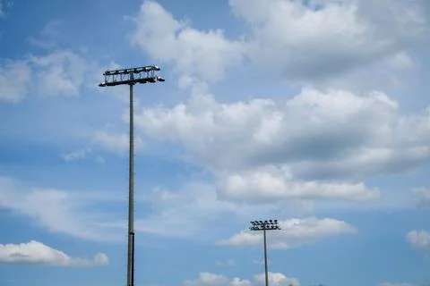 Stadium lights and dramatic cloudscape with negative space for copy. Stock Photos