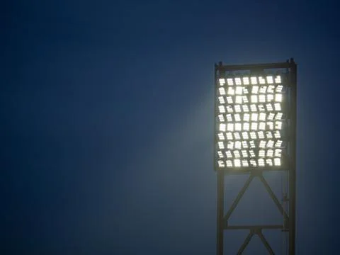 Stadium lights projecting downward on a field Stock Photos