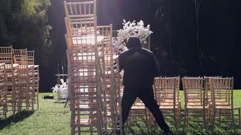 The staff arranges the chairs for the wedding Stock Footage 260884026