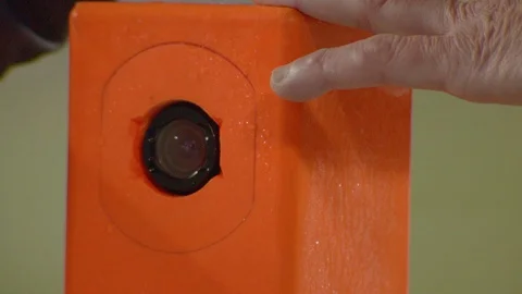 Staff cleaning camera embedded in end zone pylon during football game Stock Footage 104771964