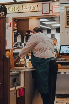 Staff cutting bread inside Chez Leon restaurant in Brussels, Belgium. Stock Photos