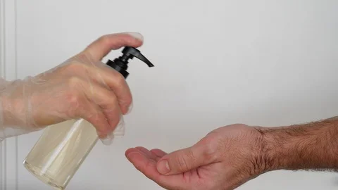 Staff help with liquid soap or sanitizer, apply cleaning liquid on man hand Stock Footage 126788246
