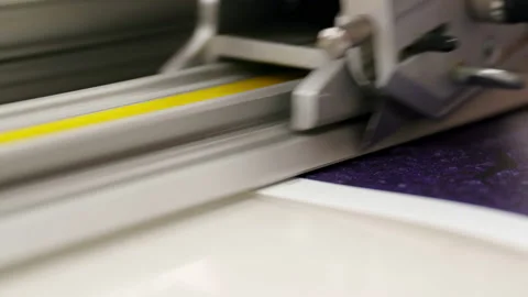 A staff member makes a small cut before cutting a sheet of paper. Stock Footage 163065087
