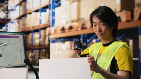 Staff member scanning barcode tracking info on tags before dispatch Stock Footage 313088498