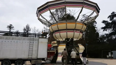 Staff members assembling colorful carousel in attraction park Stock Footage 72765135