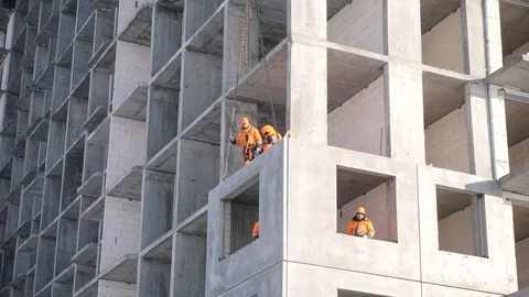 Staff mounts reinforced wall panel block lifted by crane Stock Footage 124892376