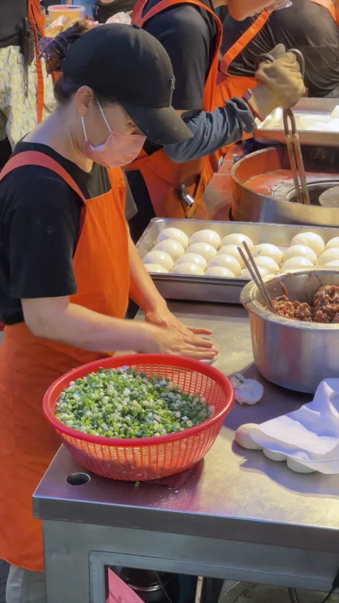 Staff In Orange Aprons Wrapping Pepper Buns With Pork And Spring Onion Video stock 342830046
