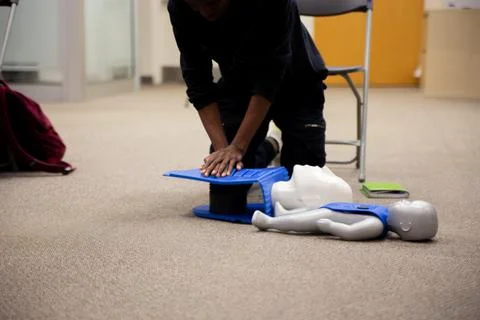 Staff practicing first aid cpr with their fingers and AED machine Stock Photos
