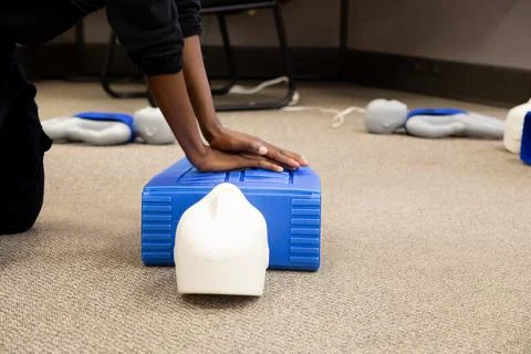 Staff practicing first aid cpr with their fingers and AED machine Stock Photos