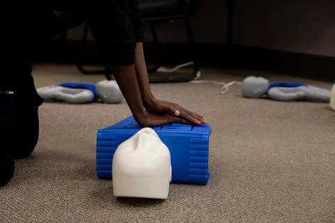 Staff practicing first aid cpr with their fingers and AED machine Stock Photos