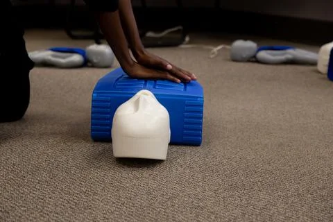 Staff practicing first aid cpr with their fingers and AED machine Stockfoto's
