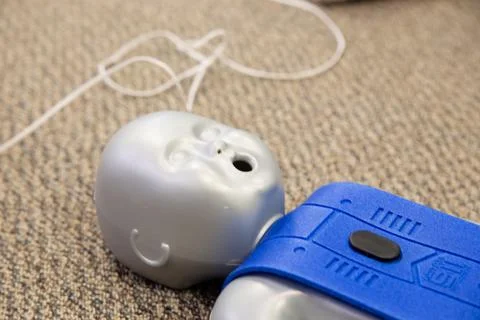 Staff practicing first aid cpr with their fingers and AED machine Stockfoto's