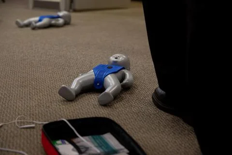 Staff practicing first aid cpr with their fingers and AED machine 스톡 사진