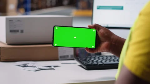 Staff reviews green screen pc in the storage room for data entry Stock Footage 313087012