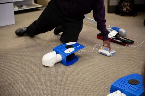 Staff setting AED machine to practice first aid Stock Photos