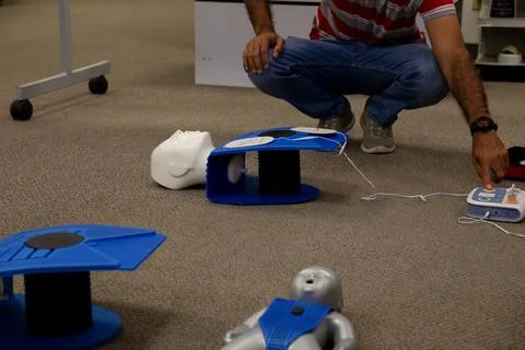 Staff setting AED machine to practice first aid Stock Photos