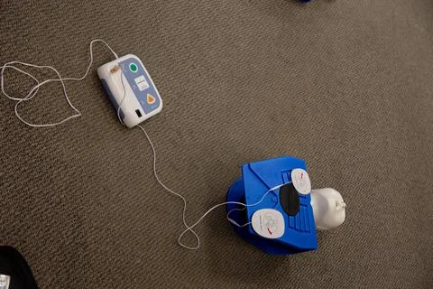 Staff setting AED machine to practice first aid 스톡 사진