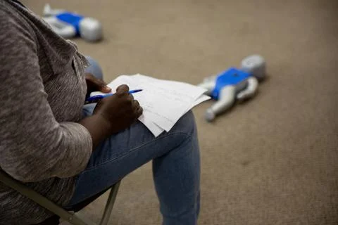Staff is taking down a note in cpr first aid class Stock Photos