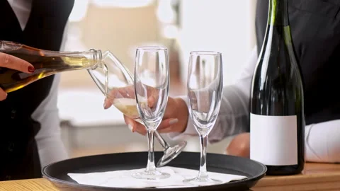 Staff waiter holding glasses, while champagne being pored into glasses. 動画素材 199633754