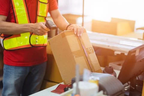 Staff worker check postal label with laser barcode scanner at products box .. Stock-Fotos