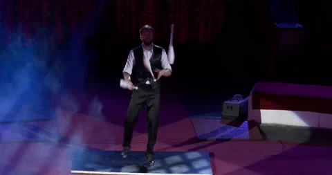 Stage of a circus with a young man juggling, smoke and lights, show, 4k Stock Footage 147486108