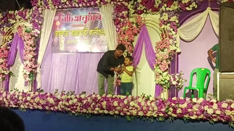 Stage Host Interacting with a Young Child on a Decorated Festive Stage Stock Footage 338400268