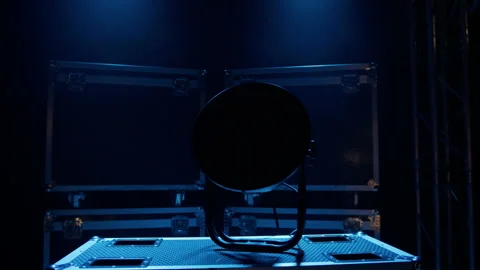 A stage lighting device that turns on against the background of boxes Stock Footage 194438825