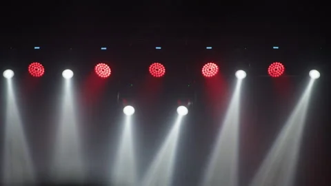 Stage lighting rig at angle with white beam and red par lights Stock Footage 334350114