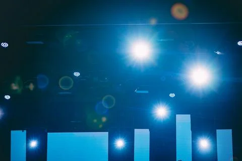 Stage lighting setup with bright spotlights illuminating a dark background,.. Stock Photos
