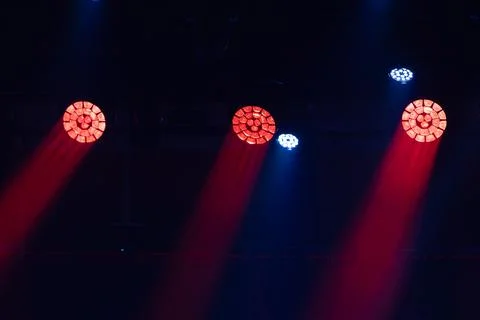 Stage lighting setup with red and blue spotlights illuminating a dark perfo.. Stock Photos