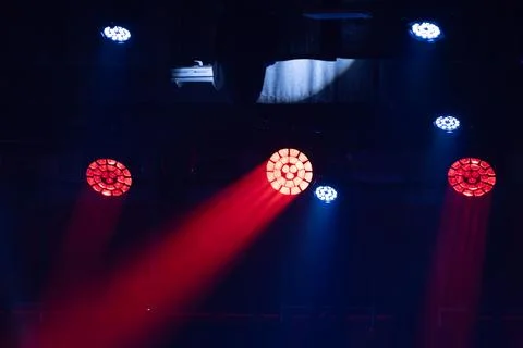 Stage lighting setup with red and blue spotlights illuminating a dark venue.. Stock Photos