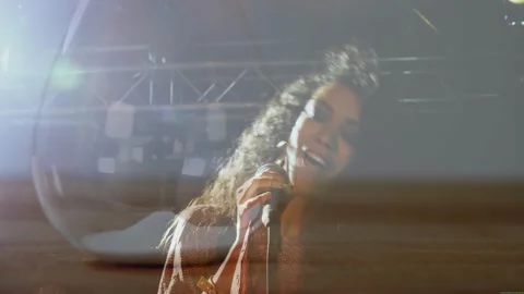 Stage lights cueing music singer, singing into mic for crowd, hair sweeping Stock Footage 334111488