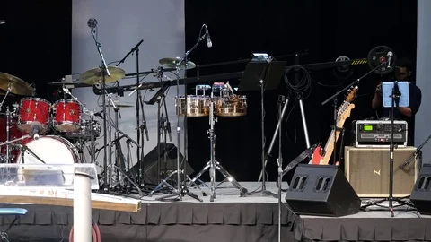Stage with music instruments before the concert. Some technicians working. Stock-Footage 85328107