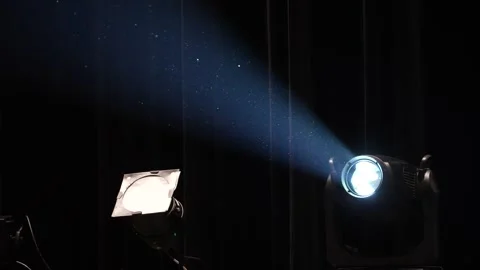 Stage spotlight emitting bright white beam through dust particles Stock Footage 346354626